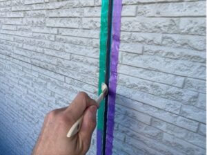 伊奈町で外壁目地のコーキング打ち替え工事、プライマー塗布作業中
