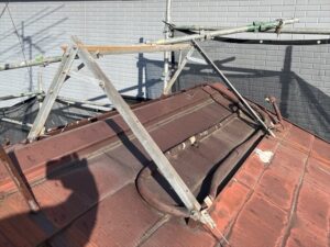 春日部市にて屋根上の温水器を撤去している写真