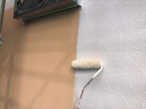 春日部市にて外壁塗装の下塗り作業中の写真